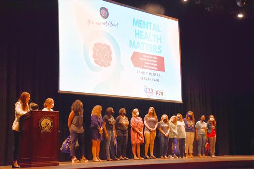 counselors on stage under a Mental Health Matters sign